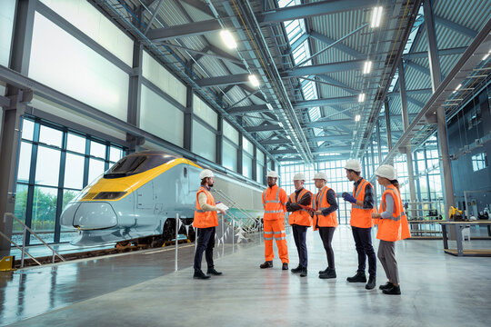 Teacher talking to apprentices at railway engineering facility