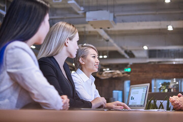 Colleagues in open plan office in business meeting