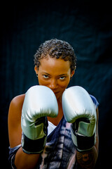 Portrait of woman wearing boxing gloves looking at camera