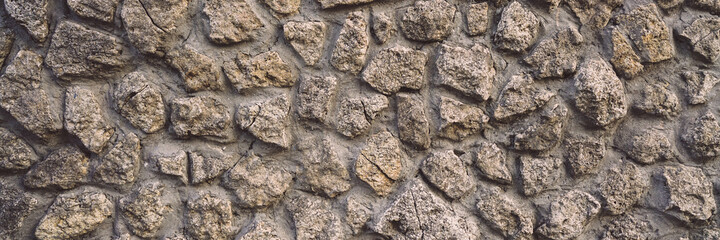 Wall of antique building with hard rough stone surface