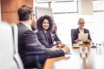 Businesswomen and men talking at conference table meeting