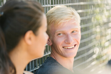 Woman and boyfriend talking by wire fence