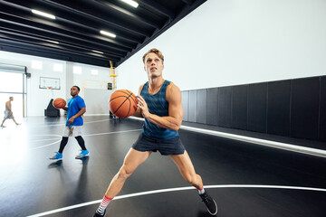Male basketball player practicing aim on court