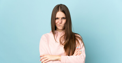 Young caucasian woman isolated on blue background with unhappy expression