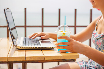 A woman working on laptop at wooden table. Woman working on laptop in a cafe