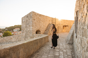 Young woman walking along City Walls, Dubrovnik, Croatia