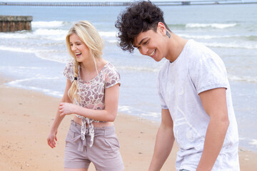 Happy young couple strolling on beach