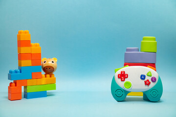 Toys and games for toddlers  concept. Toy blocks and game pad on blue background, copy space 