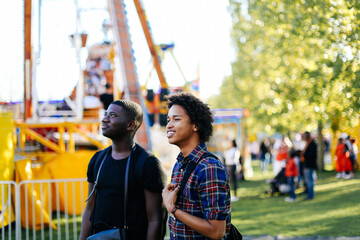 Two male friends at funfair, smiling