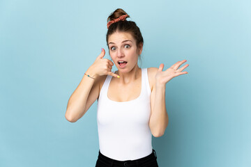 Young caucasian woman isolated on blue background making phone gesture and doubting