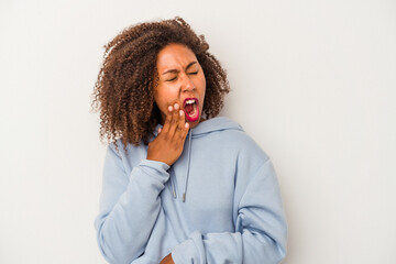 Young african american woman with curly hair isolated on white background yawning showing a tired gesture covering mouth with hand.