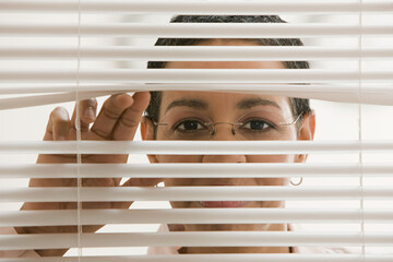 Businesswoman behind blinds
