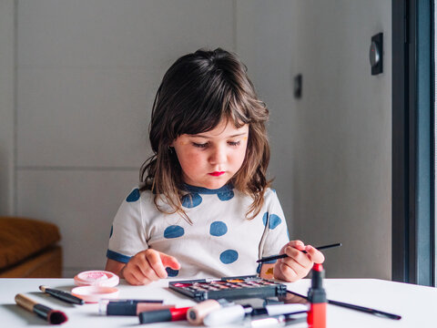 Girl applying glitter on face at home
