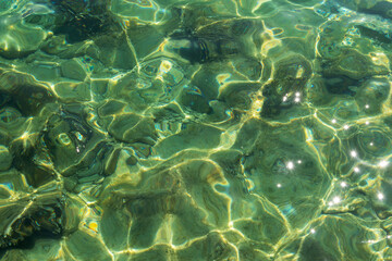 Fototapeta na wymiar Transparent sea surface with sun glare, texture, background