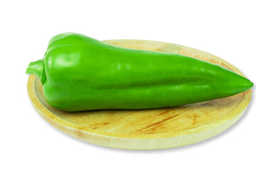 Long sweet pepper of green color on wooden plate isolated on white background. Healthy vitamin food.