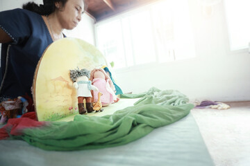 Asian  teacher telling story with hand made Waldorf dolls,home schooler and waldorf school concept background.