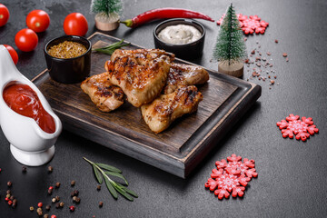 Grilled spicy chicken wings on a dark background with spices and herbs