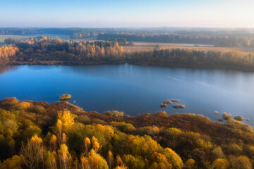 Obraz premium Landscape of aerial view sunrise above the river. Yellow foliage and dry grass on bank of the river. Colorful nature in late autumn.