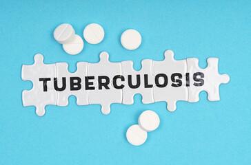 On a blue background pills and puzzles with the inscription - TUBERCULOSIS