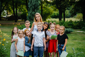 A teacher teaches a class of children in an outdoor Park. Back to school, learning during the pandemic