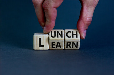 Lunch and learn symbol. Businessman turns wooden cubes and changes a concept word 'lunch' to 'learn' on a beautiful grey background. Copy space. Business, educational and lunch and learn concept.