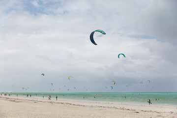 Zanzibar, Tanzania, January 22, 2021: Surfer beach, turquoise sea, many people ride surfboards and kites.
