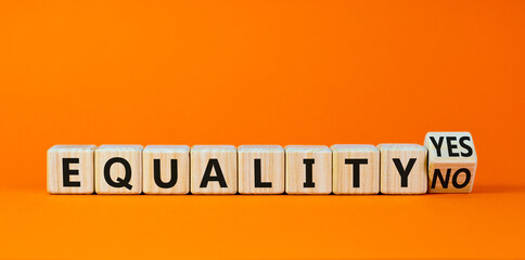 Equality symbol. Turned a wooden cube and changed words 'equality no' to 'equality yes'. Beautiful orange background. Business and equality concept, copy space.