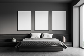 Dark bedroom interior with large bed, three empty posters