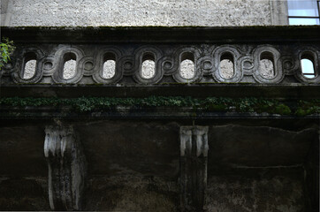 concrete balustrade of the balcony with a geometric pattern covered with moss