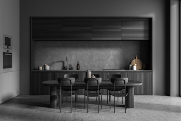 Dark kitchen room interior with dining table, chairs, concrete floor