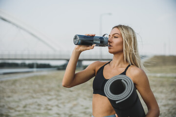 Woman Take A Break And Drinking Water During Outdoor Working Out