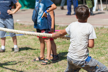 Small children are pulling the rope. A game for children.