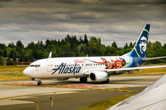 Seattle, Washington State, USA - June 2019: Alaska Airlines Boeing 737 taxiing for take off. The aircaft carries an "Incredibles 2" paint scheme as part of sponsored advertising.