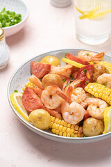 Shrimp boil heap with corn, baby potatoes, sausage and lemons.