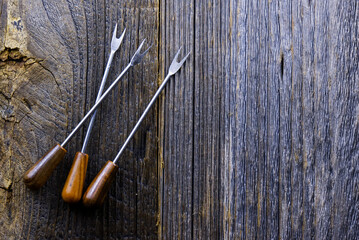 Small wooden cutlery on a dark wooden background with copy space
