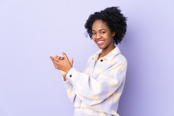 Young African American woman isolated on purple background applauding