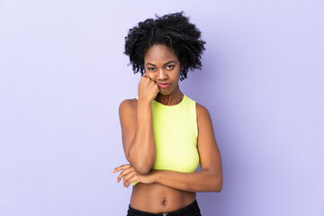 Young African American woman isolated on purple background with tired and bored expression