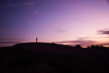 silhouette person standing looking at the sunrise