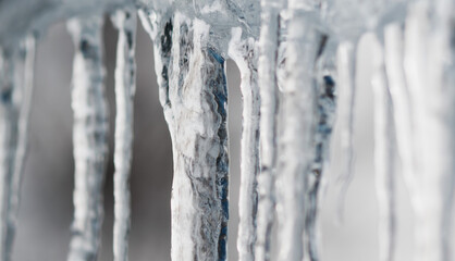 Naklejka na ściany i meble Frozen ice icicles hanging from the roof