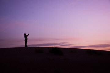 Fototapeta na wymiar Silhouette of a man on a dune at sunset