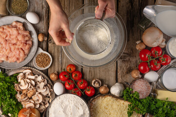 A beautiful composition of ingredients: flour, mushrooms, herbs, tomatoes, eggs, spices. The chef prepares pizza, ravioli, pie. pasta with mushrooms and vegetables. High angle view.