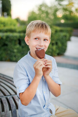 blonde boy in blue shirt eating popsicle ice cream