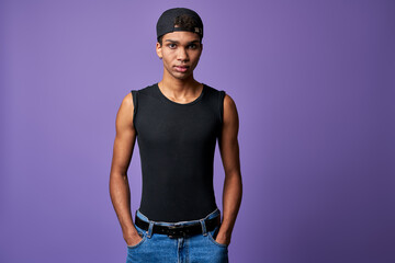 Portrait young transgender brunette man in black t-shirt, cap, blue jeans. Hispanic trans gender male - obrazy, fototapety, plakaty