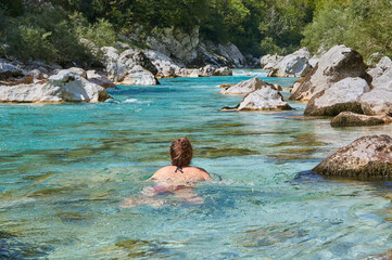 Women swimming in the turqoise river Soca in Slovenia.