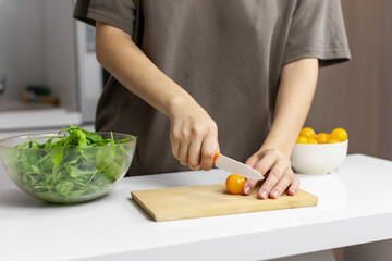 Woman Making raw green salad with cherries