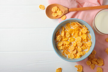  Crispy cornflakes with milk for breakfast on the table close-up.