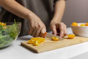 Woman Making raw green salad with cherries