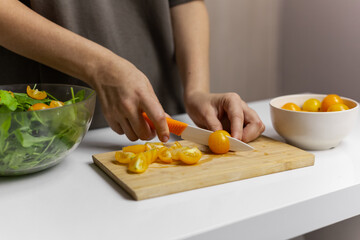 Woman Making raw green salad with cherries
