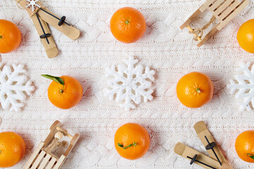 winter flat lay with snowflakes, mandarins, sleds and skis
