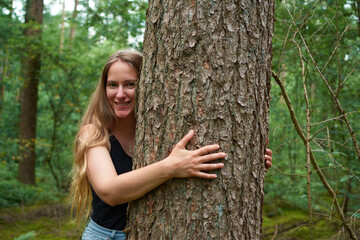 A portrait of a young Italian woman hugging a tree in a forest